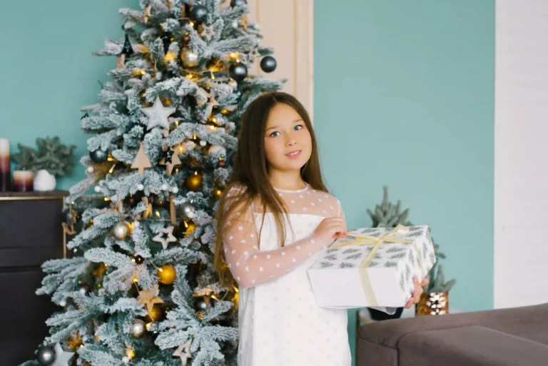 16-year-old girl opening Christmas gifts in cozy holiday living room with festive lights and decorated tree